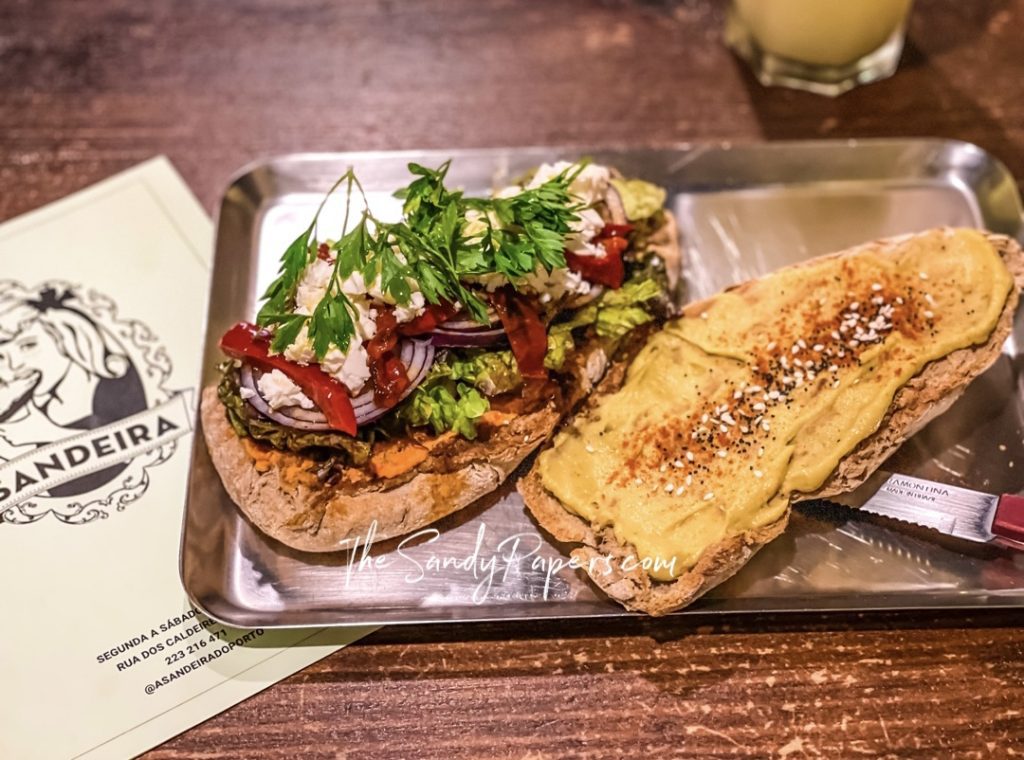 Open-faced sandwich with grilled meat, pico de gallo, and toasted bread on metal tray.