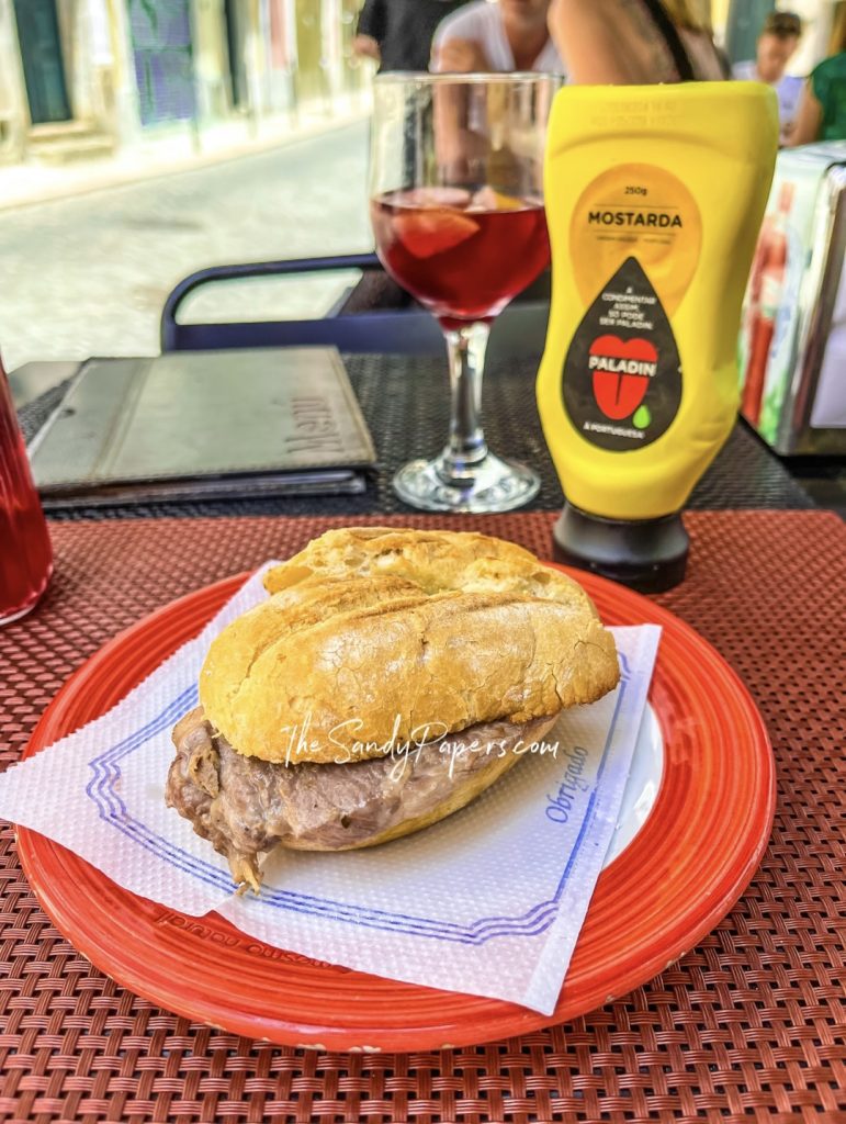 A sandwich with meat on a bun on a red plate.